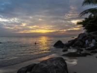 Sonnenuntergangsstimmung am felsigen Strand der Kata Noi Beach